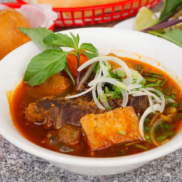 Close-up of a bowl of Vietnamese Pho Bo To Grill with beef, vegetables, and broth.